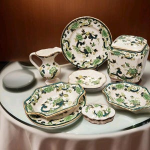 Puede incluir: Un juego de porcelana con estampado floral verde y blanco, que incluye una jarra de crema, un azucarero, un plato pequeño, un plato grande, un tazón pequeño, un tazón grande y una caja de joyas.