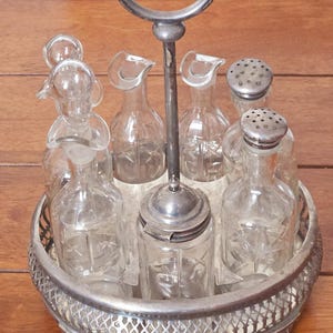 Antique VIctorian silver-plated cruet set with 6 cut-glass etched bottles. on footed stand