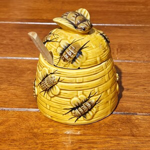 Gloednieuwe keramische honingpot in de vorm van een bijenkorf, vintage stijl, vlechtwerk met 3D-effect van een hommel.