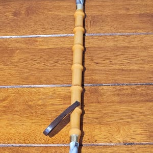 May include: A long-handled back scratcher with a bamboo-style shaft and a hand-shaped scratching end. The handle has a marbled blue and white design. A leather strap is attached near the top.