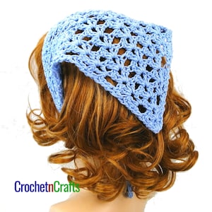 May include: A light blue crocheted headband with a delicate openwork pattern. The headband is tied at the back of the head.