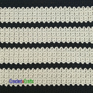 May include: Close-up of a crocheted fabric with alternating bands of off-white and black. The off-white bands have a scalloped edge. The text "Crochet n Crafts" is at the bottom in multiple colors.