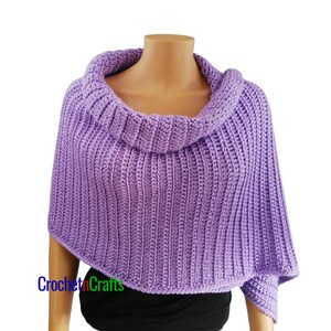 May include: A lilac-colored, handmade crochet poncho with a wide, ribbed cowl neck. The poncho is displayed on a mannequin and features a textured, vertical ribbing pattern. The text "Crochet n Crafts" is visible on the lower left side.