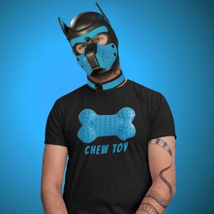 May include: A person wearing a black t-shirt with a blue chew toy graphic and the text "CHEW TOY". They are also wearing a black leather dog mask with blue accents and a blue collar.