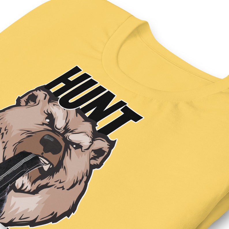 May include: Yellow t-shirt with a brown bear graphic and the word "HUNT" in black text.