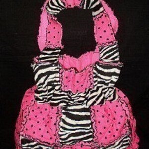 May include: A pink and black patchwork tote bag with a zebra print and polka dot fabric. The bag has a single strap and multiple pockets.