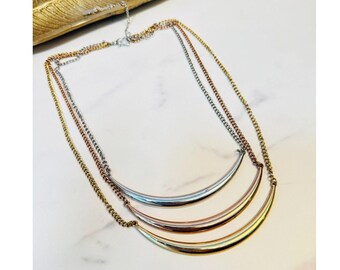 Collar con barra curva de Jennifer Lopez, joyería en capas de metales mixtos oro rosa y plata, inspirado en celebridades.