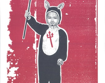 May include: A child dressed in a black devil costume with red horns and a red trident, standing against a red background.