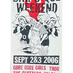 May include: A black and white poster advertising a Labor Day Barbeque Weekend music festival. The poster features a red flame and three cartoon figures. The text on the poster reads "Labor Day Barbeque Weekend", "Sept 2&3 2006", "Gore Gore Girls Thor", "The Clutters Zolar X", "Hurts To Laugh", and "The Basement Nashville".