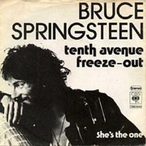 May include: Black and white photo of Bruce Springsteen, a musician, with the text "BRUCE SPRINGSTEEN tenth avenue freeze-out she's the one" on the cover of a vinyl record.