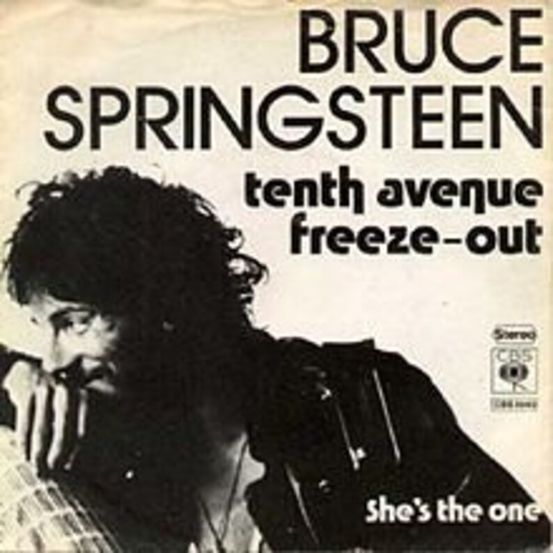 May include: Black and white photo of Bruce Springsteen, a musician, with the text "BRUCE SPRINGSTEEN tenth avenue freeze-out she's the one" on the cover of a vinyl record.