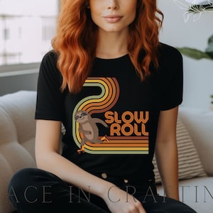 May include: A black t-shirt with a retro-style graphic of a sloth on a skateboard. The graphic features a rainbow of colors and the text "Slow Roll".