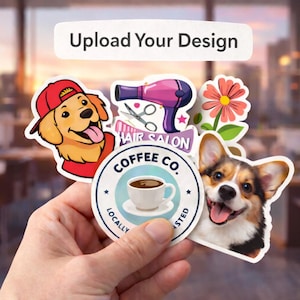May include: A hand holding a collection of stickers with various designs. Stickers include a smiling dog wearing a red cap, a pink and purple hair dryer, a flower, and a coffee cup with the text "Coffee Co."