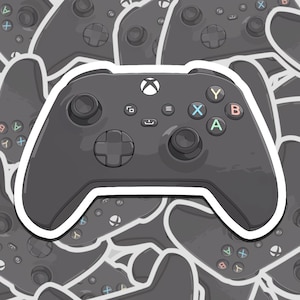 May include: A black Xbox controller with white buttons and a white outline. The controller is surrounded by other black Xbox controllers.