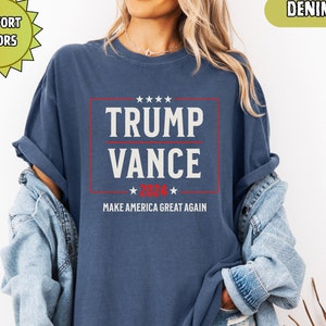 May include: A navy blue t-shirt with a white rectangle containing the text "TRUMP VANCE 2024" in red and white. The text "MAKE AMERICA GREAT AGAIN" is printed below the rectangle.