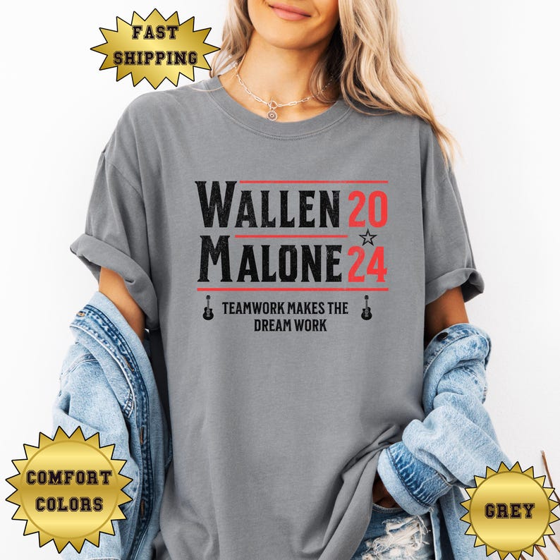May include: A grey t-shirt with the text "WALLEN 20 ☆ MALONE 24" in black and red. The text "TEAMWORK MAKES THE DREAM WORK" is printed below in black. There are guitar images on either side of the text.