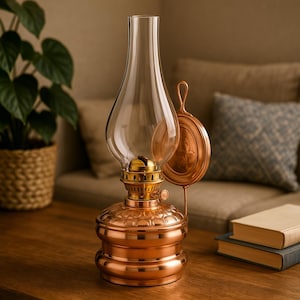 May include: A copper oil lamp with a glass chimney and a decorative wall mount. The lamp has a round base with a textured design and a gold-coloured wick holder.