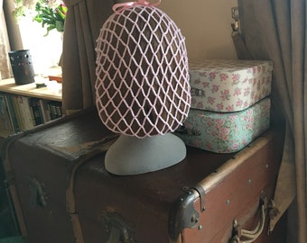 Pale pink 1940s style snood hairnet with a pink ribbon for an authentic vintage hairstyle