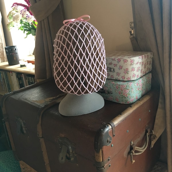 Pale pink 1940s style snood hairnet with a pink ribbon for an authentic vintage hairstyle