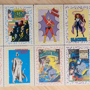 May include: A sheet of vintage comic book trading cards featuring DC Comics characters. The cards showcase heroes like Green Lantern, Aqualad, Adam Strange, Blackfire, and Batman. The cards are rectangular with colorful illustrations and text.