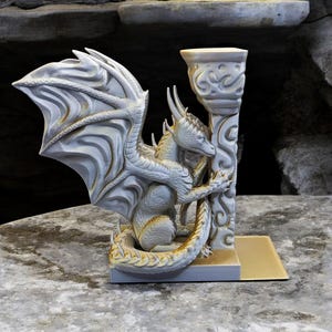 A 3D-printed Dragon Bookend, featuring intricate wings, fierce claws, and customizable color options. This mythical dragon bookend is both decorative and functional, perfect for fantasy lovers, book collectors, and unique bookshelf organization.