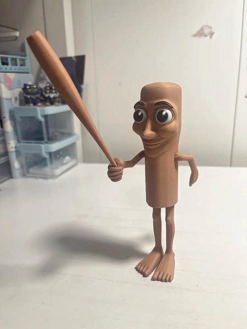 May include: A brown figurine of a person with a long, thin body and large eyes holding a wooden baseball bat.