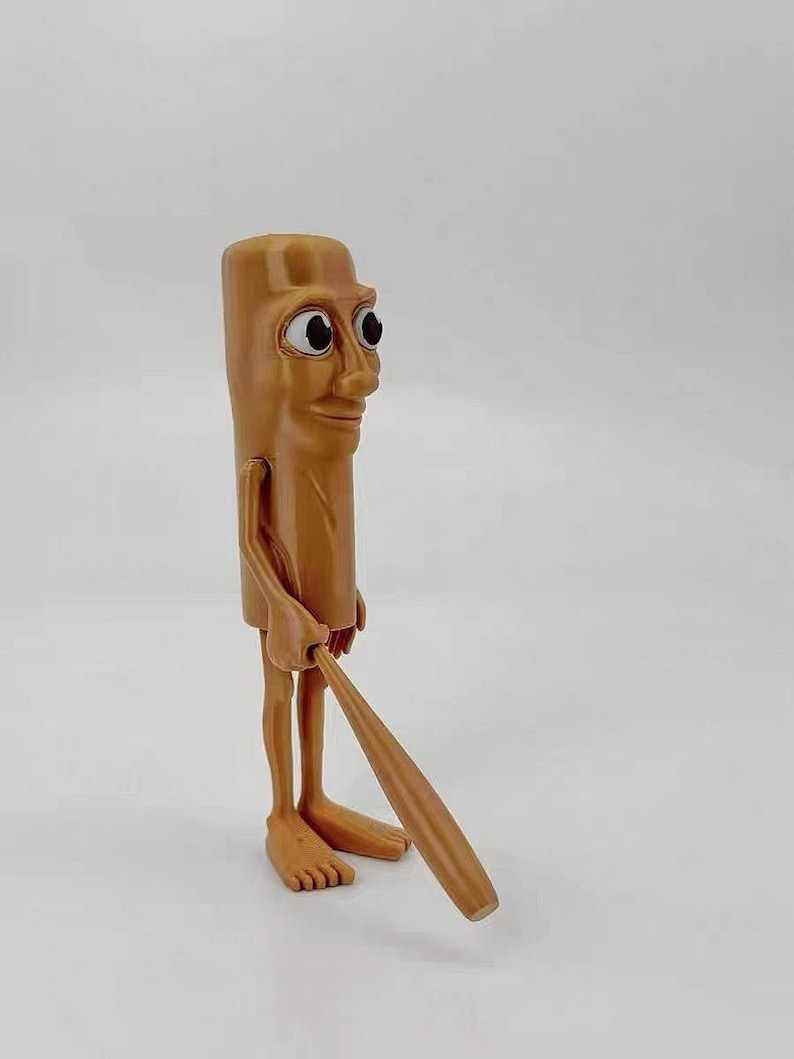 May include: A brown figurine of a person with a long, thin body and large eyes. The figurine is holding a wooden baseball bat.
