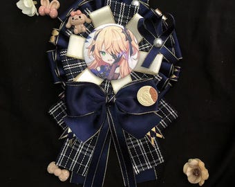 May include: A blue and white plaid ribbon with a gold trim and a blue bow. The ribbon has a white circle with a cartoon image of a girl with blonde hair and blue eyes. The ribbon is decorated with small white flowers and a gold coin.