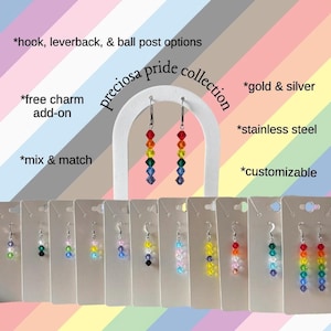 May include: A collection of colorful beaded earrings in various styles. The earrings are displayed on white cards, with options for hook, leverback, and ball post styles. The text "preciosa pride collection" is visible, along with options for gold and silver, stainless steel, and customizable features.