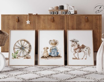 May include: Three watercolor prints in brown frames depicting a cowboy with a dog, a horse with a saddle, and a wagon wheel. The prints are hung on a wooden wall.
