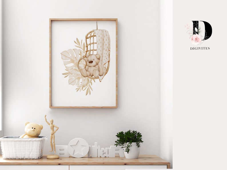 May include: A watercolor illustration of a brown teddy bear sitting in a wicker chair with a white and brown patterned cushion. The bear is surrounded by beige and brown leaves and plants. The illustration is framed in a light brown frame.