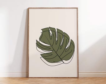 May include: A framed print featuring a stylized illustration of a Monstera leaf. The leaf is rendered in shades of green with a black outline, set against a cream-colored background. The artwork is displayed in a wooden frame, suitable for wall decor.