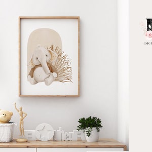May include: A watercolor illustration of a brown and gray elephant with a brown and beige background. The elephant is sitting in a patch of brown and beige grass. The illustration is framed in a light brown frame.