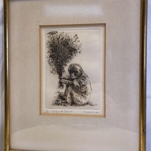 Op de afbeelding: Een ingelijste zwart-wit ets toont een aap die een groot boeket bloemen vasthoudt. Het kunstwerk bevindt zich in een goudkleurige lijst met een witte passe-partout. De ets is gesigneerd en getiteld "Boy Marley with Bouquet".