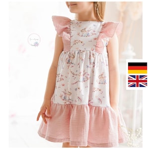 Op de afbeelding: Een wit en roze mouwloos jurkje met een bloemenprint en een gerimpelde halslijn. Het jurkje heeft een gelaagde rok en is gemaakt van een zachte, comfortabele stof.