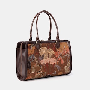 May include: A brown handbag with a floral pattern and two handles. The bag has a rectangular shape with a dark brown leather trim and handles. The floral pattern includes shades of brown, gold, and pink.