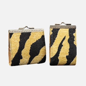 May include: Two rectangular coin purses with a tiger stripe pattern in black and gold. The purses have a metal clasp closure and a decorative metal frame. The purses are made of a textured fabric.