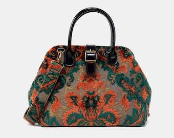 Könnte beinhalten: Eine grüne, orange und braune gemusterte Handtasche mit einem schwarzen Henkel und einer schwarzen Schnalle. Die Tasche hat einen abnehmbaren Schultergurt.