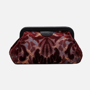 May include: A burgundy velvet clutch with a black metal frame and a floral pattern.