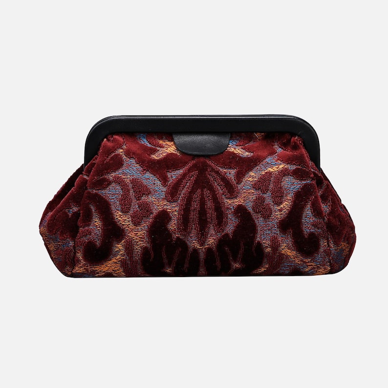 May include: A burgundy velvet clutch with a black metal frame and a floral pattern.