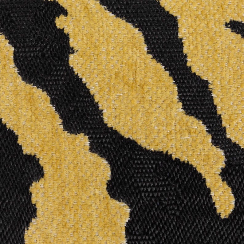 Peut inclure: Gros plan sur un tissu avec un motif abstrait noir et or. Le tissu a une surface textur&eacute;e et duveteuse.