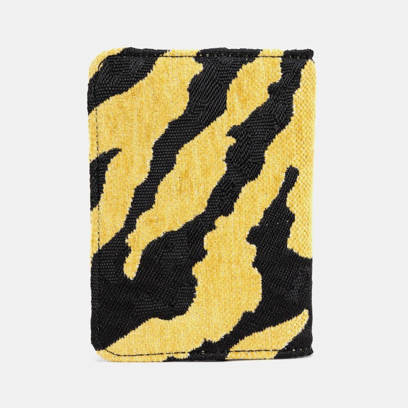 Peut inclure: Un portefeuille en tissu ray&eacute; jaune et noir avec une fermeture &agrave; glissi&egrave;re.