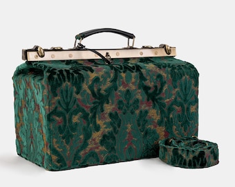 May include: A green velvet doctor's bag with a brass frame and a detachable strap. The bag has a floral pattern.