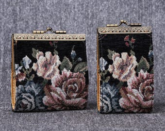 May include: Two black floral patterned coin purses with gold metal frames. The purses have a floral design with pink, white, and green flowers.
