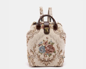 May include: A beige tapestry backpack with a floral design and brown leather accents. The backpack has a top handle and adjustable straps.