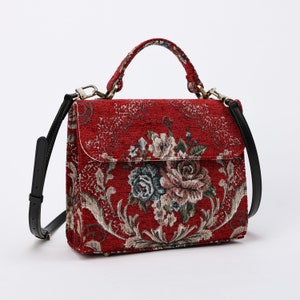 Bolso de mano artesanal con asa superior, bandolera con solapa frontal y estampado floral rojo.