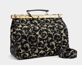 May include: Black and gold patterned handbag with a matching shoulder strap. The bag features a structured design with a gold-toned clasp and handle. The fabric has a repeating floral scroll pattern.
