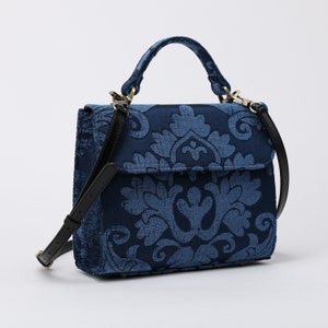 Bolso de mano artesanal con asa superior, bandolera con solapa frontal y bandolera en color azul rey.