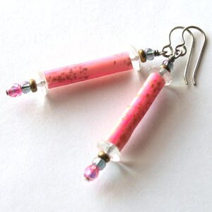 May include: Pink and gold earrings with clear glass beads and silver hooks.