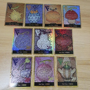 Pode incluir: Uma caneca de cerâmica branca com uma alça preta e o texto "But First, Coffee" em preto, com uma fonte manuscrita. A caneca está sobre uma superfície branca.